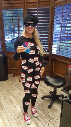 a woman in a black and red outfit is holding up some candy bar wrappers