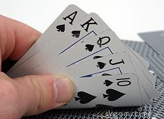 a person holding four playing cards in their hand