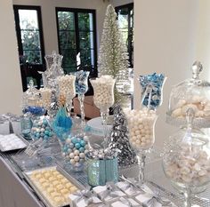 a table topped with lots of different types of candy and candies on top of glass trays