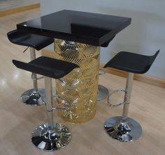 three stools and a table in the middle of a room with wood flooring