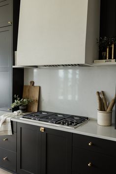 a stove top oven sitting inside of a kitchen next to wooden cutting boards and utensils