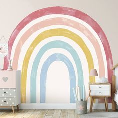 a child's room with a rainbow wall mural and wooden dresser in the corner