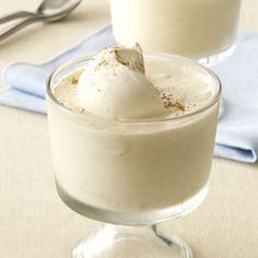 two glasses filled with dessert sitting on top of a table