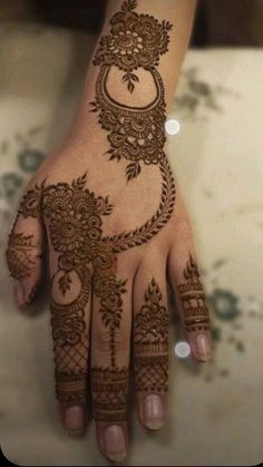 a woman's hand with henna tattoos on it