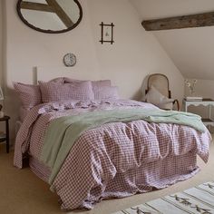 a bed in a bedroom with pink and green comforter