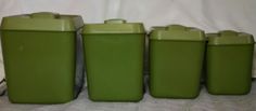 four green canisters are lined up on the table