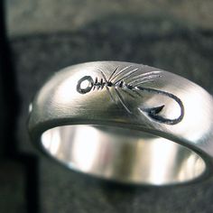 a silver ring with an arrow engraved on it