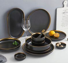 black and gold dinnerware set on white table