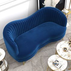 a blue couch sitting in the middle of a living room next to two end tables