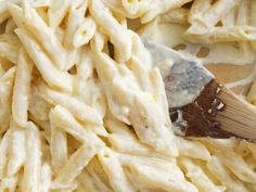 a wooden spatula is being used to stir pasta