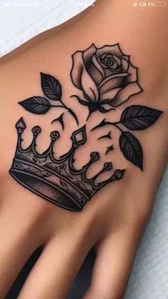 a black and white rose with a crown tattoo on the left hand is shown in this image