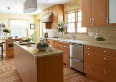 a large kitchen with wooden floors and stainless steel appliances