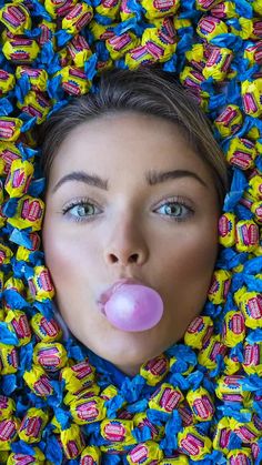 a woman sticking her tongue out in the middle of candy candies, as if it were chewing gum