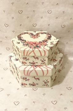 three boxes are stacked on top of each other, with hearts and flowers all over them