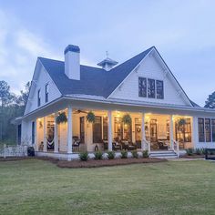 a large white house sitting on top of a lush green field