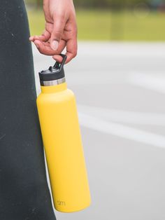 a person holding onto a yellow water bottle