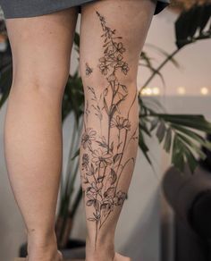 a woman's legs with flowers tattooed on them