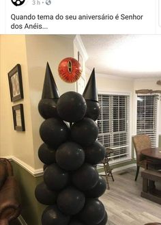 black balloons are stacked on top of each other in front of a dining room table