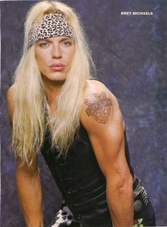 a man with long blonde hair and tattoos on his arm