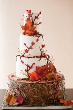 a three tiered cake with leaves on it