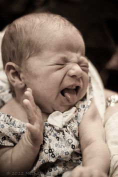 a baby crying with its mouth wide open