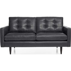 a black leather couch sitting on top of a white floor