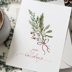 a card with the words happy holidays written on it next to a cup of coffee