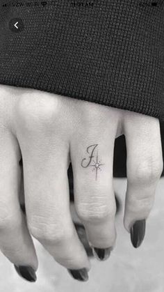 a person with a cross tattoo on their finger