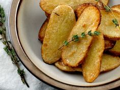 a white bowl filled with sliced potatoes on top of a table