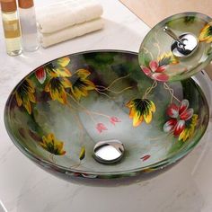 a glass sink with flowers painted on it