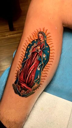 a man with a tattoo on his arm that has an image of the virgin mary