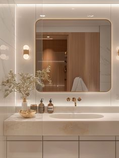 a bathroom sink with a mirror above it next to a vase and soap dispenser