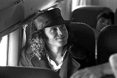 a woman wearing a hat sitting in the back seat of a car