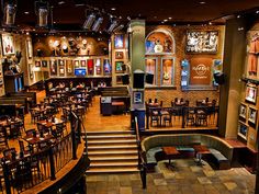 the inside of a restaurant with tables, chairs and pictures on the wall above it