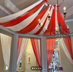 a red, white and blue canopy with candles hanging from it's ceiling in a room