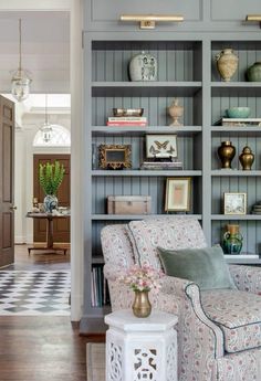 a living room filled with furniture and bookshelves covered in lots of different types of items