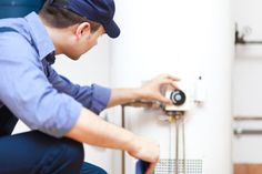 a man is fixing a water heater