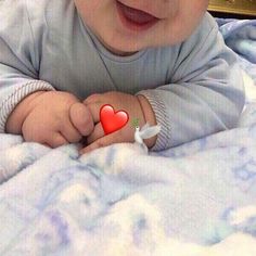 a baby with a red heart on it's finger