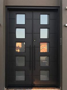 a black double door with glass panels on the front and side of a house in arizona