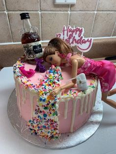 a birthday cake with a doll laying on it