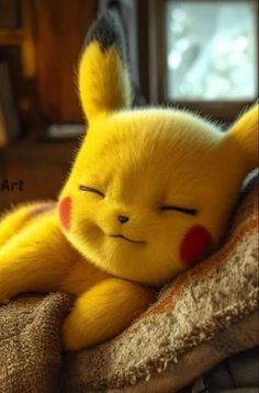 a yellow stuffed animal laying on top of a bed next to a window with it's eyes closed