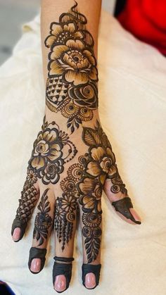 a woman's hand is decorated with hennap and flower designs on it