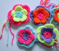 four crocheted flowers are sitting next to each other