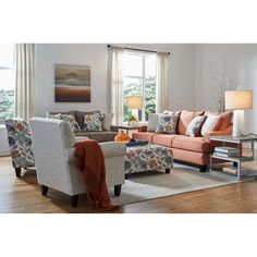 a living room filled with furniture and a lamp on top of a hard wood floor