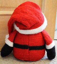 a knitted santa clause doll sitting on the floor