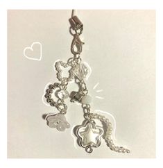 a keychain with charms attached to it on a white surface and some hearts