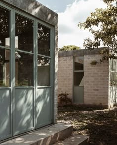 an exterior view of a brick building with glass doors and steps leading up to the front door