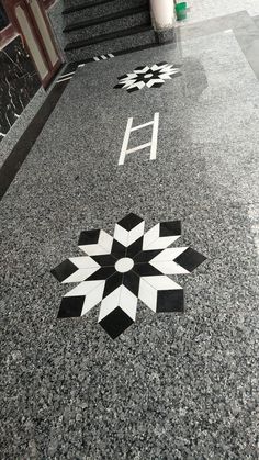 the floor is made up of black and white tiles with geometric designs on them, as well as letters that spell out h