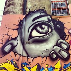 graffiti on the side of a building with an eye painted on it's face