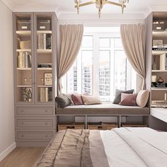 a bed sitting under a window in a bedroom next to a book shelf filled with books